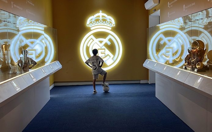 Child admiring Real Madrid logo at Real Madrid World, Dubai.