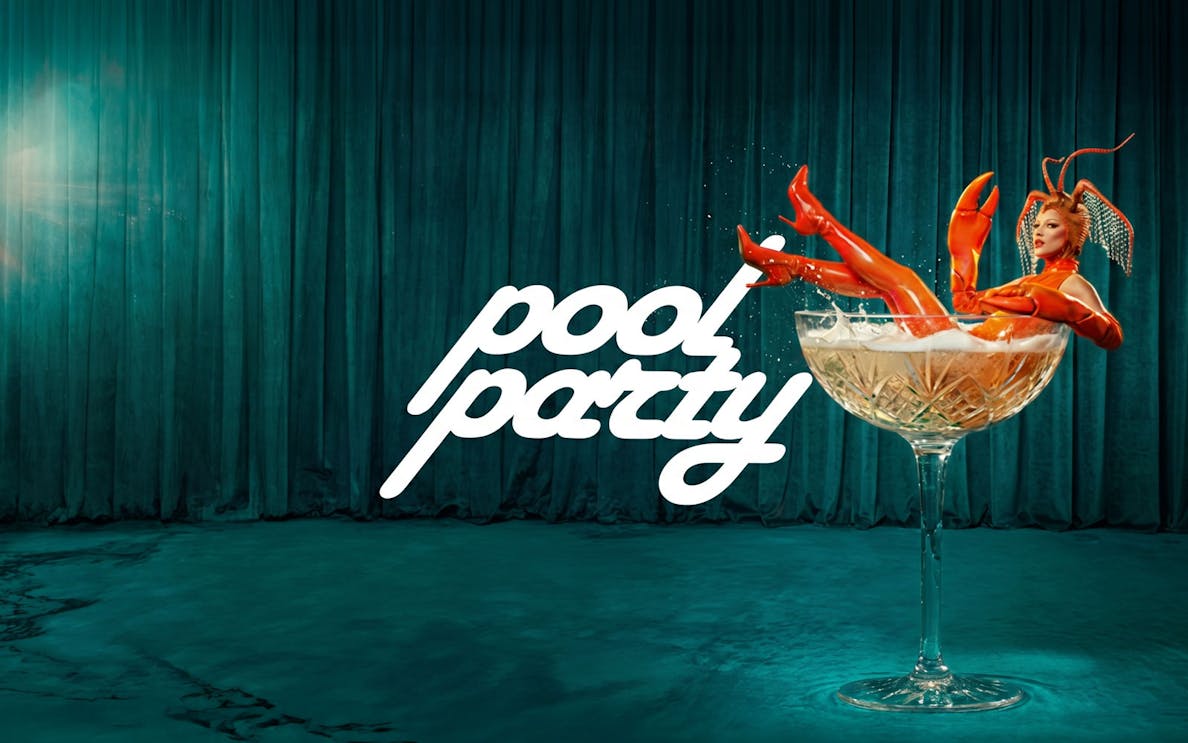 Lobster-themed performer in a champagne glass at Ibiza pool party.