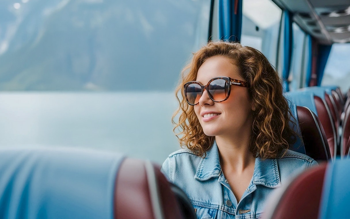 Traveler enjoying scenic view from AC coach, Hallstatt.