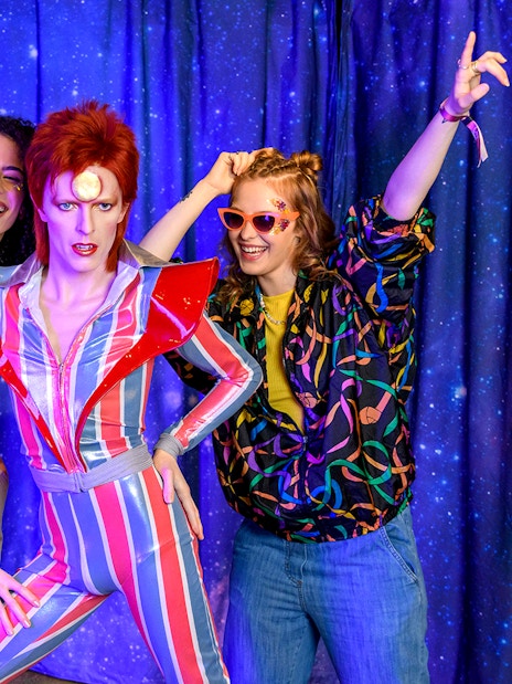 Visitors posing with a wax figure at Madame Tussauds, London.