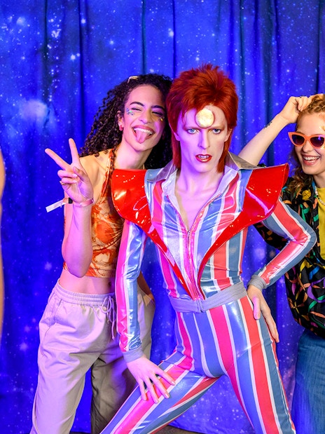 Visitors posing with a wax figure at Madame Tussauds, London.