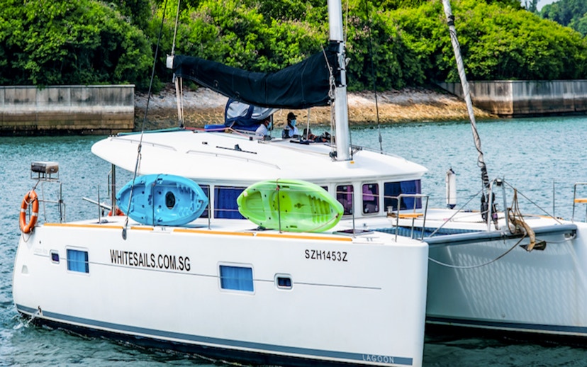 Private yacht charter SunRise with kayaks on deck in a scenic coastal area.