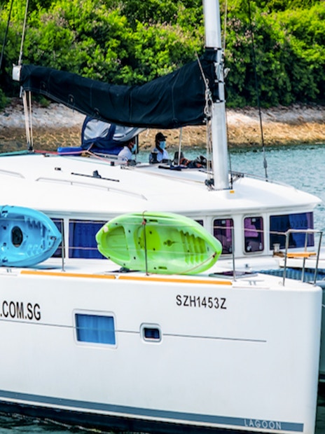 Private yacht charter SunRise with kayaks on deck in a scenic coastal area.