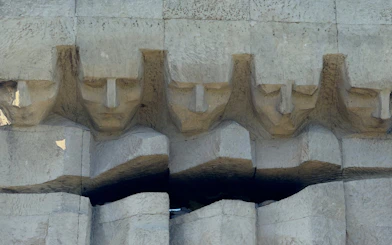 Stone relief of faces at Plaszow Concentration Camp memorial in Krakow.