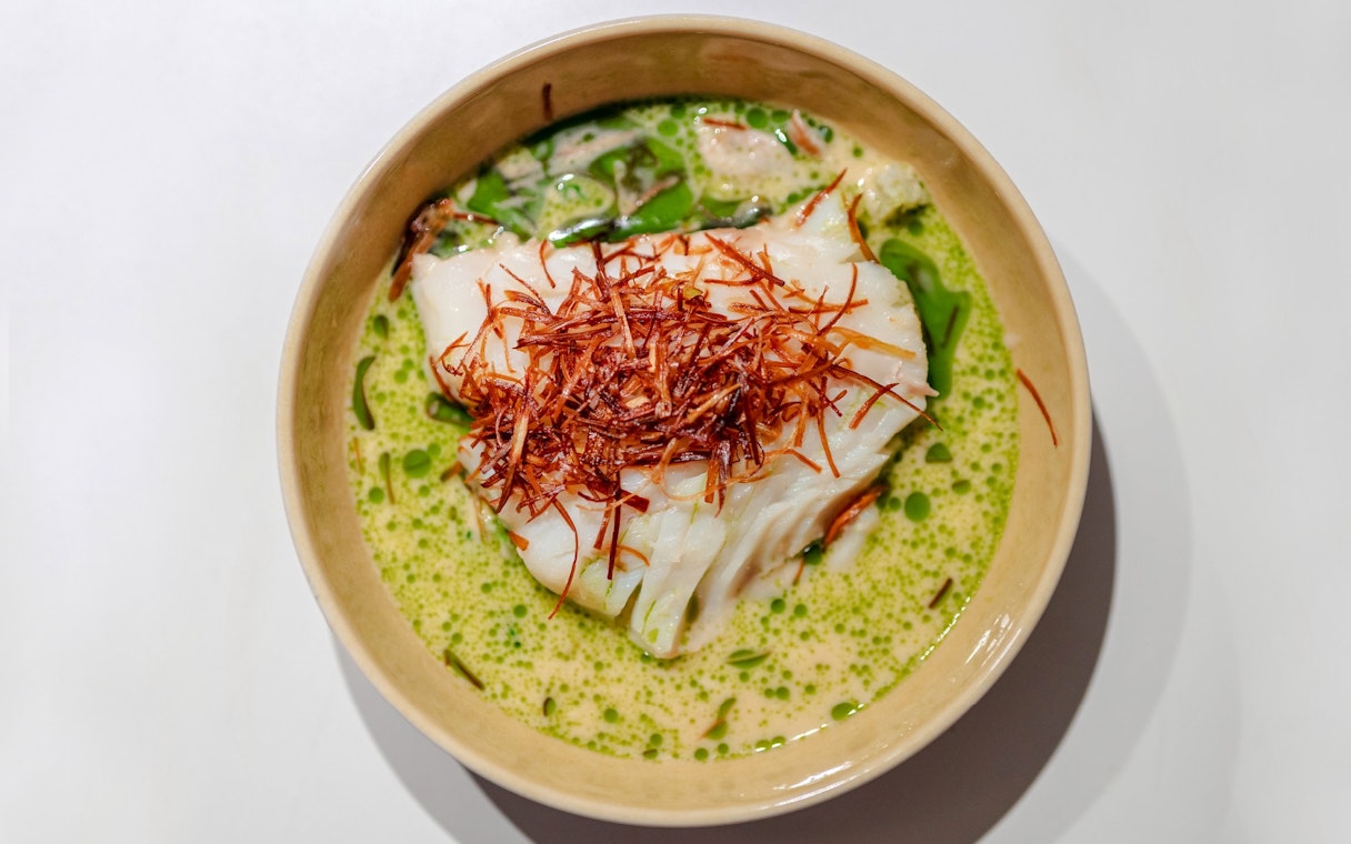 White fish with crispy garnish in green sauce, served on a Stavanger dinner cruise.