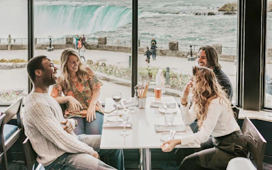 Dining with a view of Niagara Falls on a Toronto day tour with Hornblower Cruise.