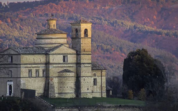 Renaissance church in Urbino with autumn hills in the background.