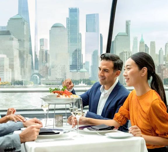 Dining on a New York City cruise with skyline views in the background.