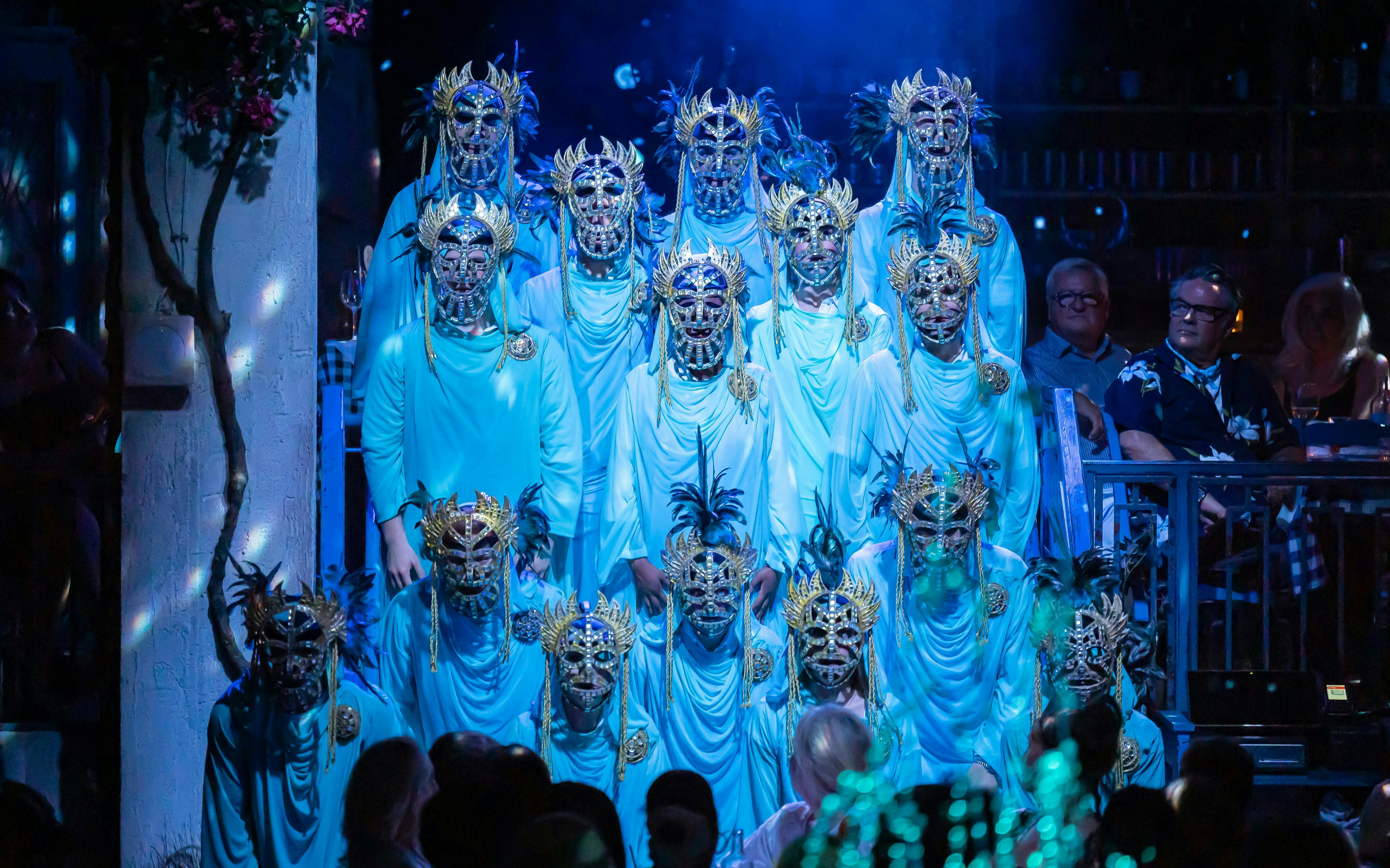 Performers in ornate masks during Mamma Mia! The Party show.