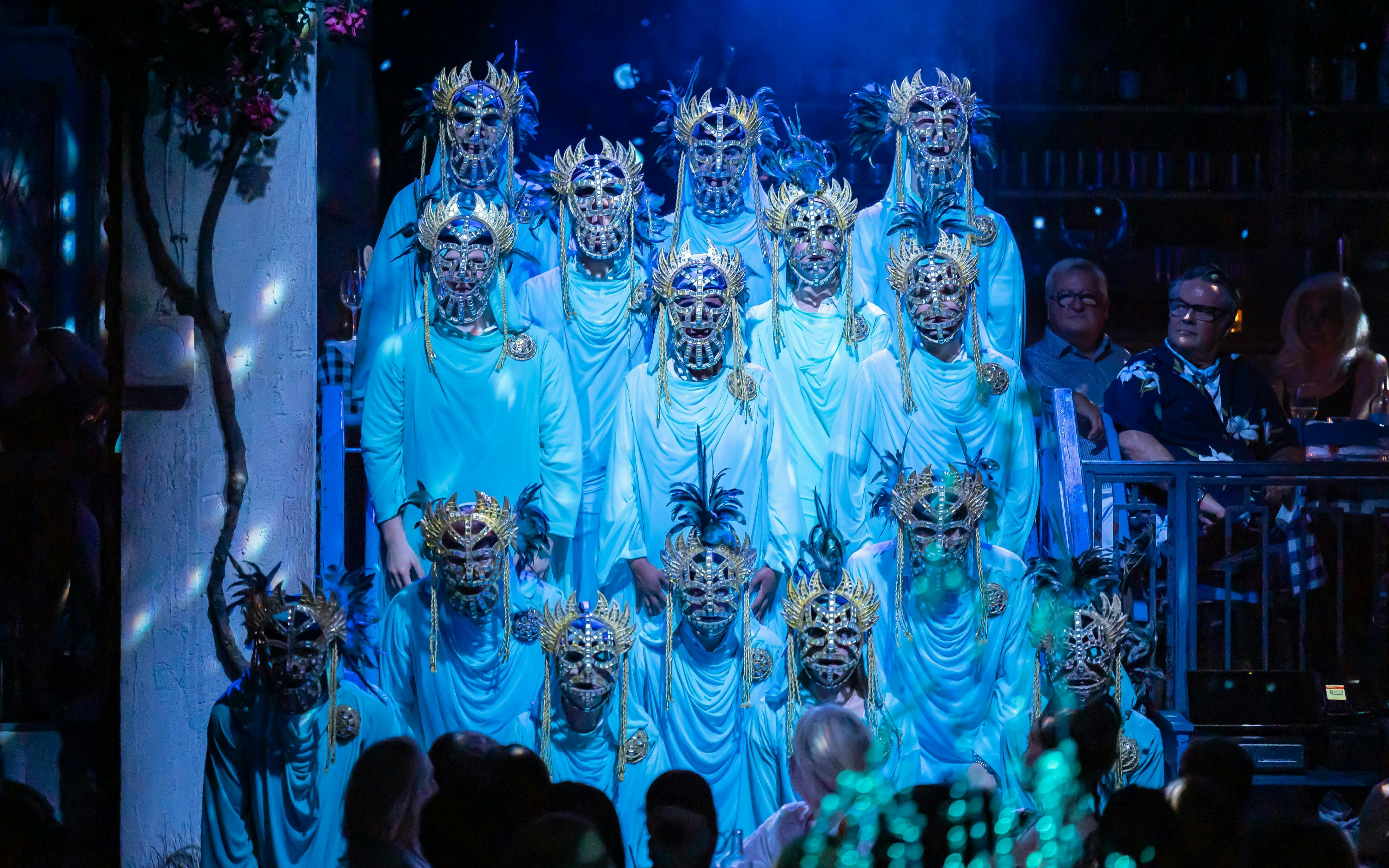 Performers in ornate masks during Mamma Mia! The Party show.