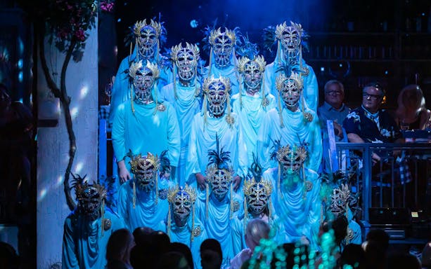 Performers in ornate masks during Mamma Mia! The Party show.