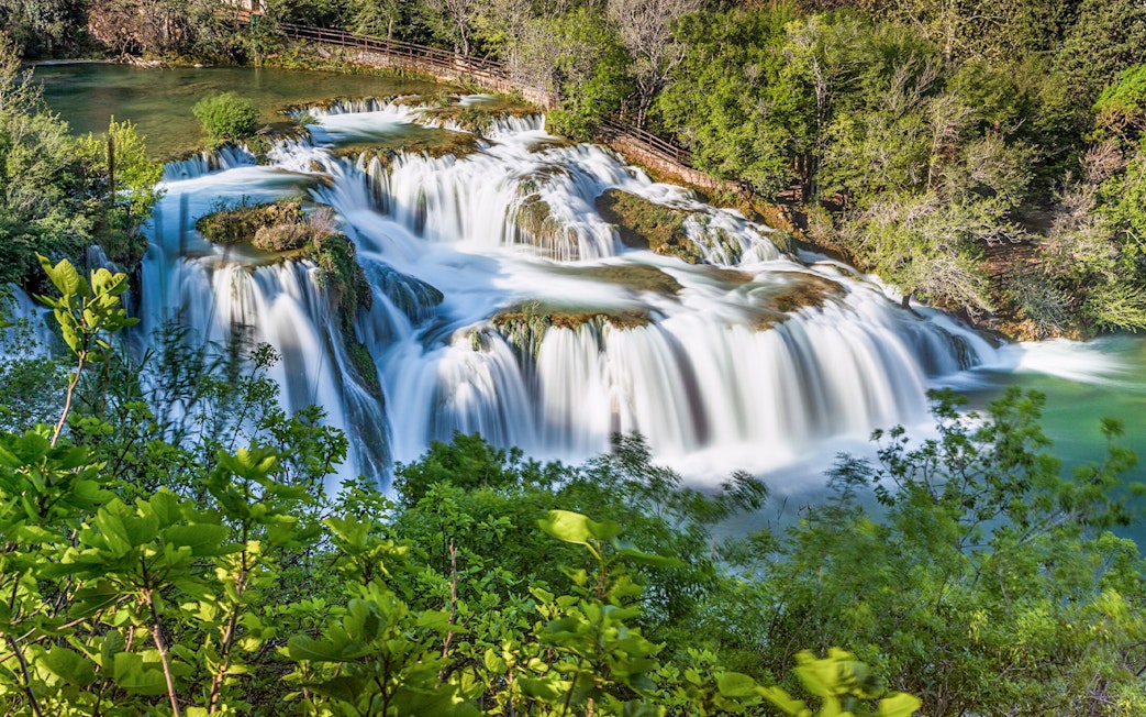 Waterfalls at Krka National Park surrounded by lush greenery.