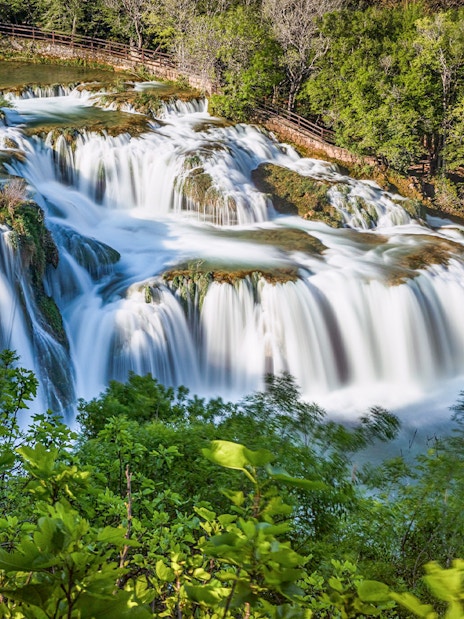 Waterfalls at Krka National Park surrounded by lush greenery.