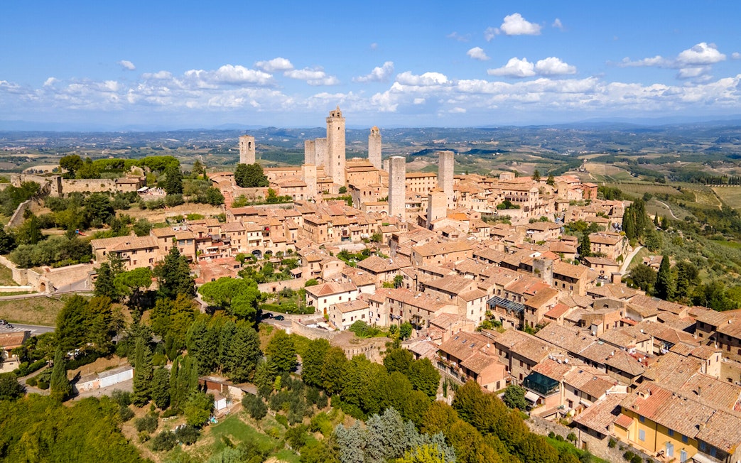 Aerial view of San Gimignano with medieval towers and surrounding countryside.