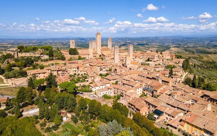 Aerial view of San Gimignano with medieval towers and surrounding countryside.