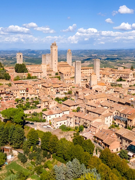 Aerial view of San Gimignano with medieval towers and surrounding countryside.