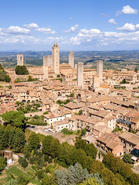 Aerial view of San Gimignano with medieval towers and surrounding countryside.
