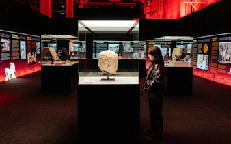 Pompeia exhibit at IDEAL Barcelona with visitor viewing ancient sculpture.