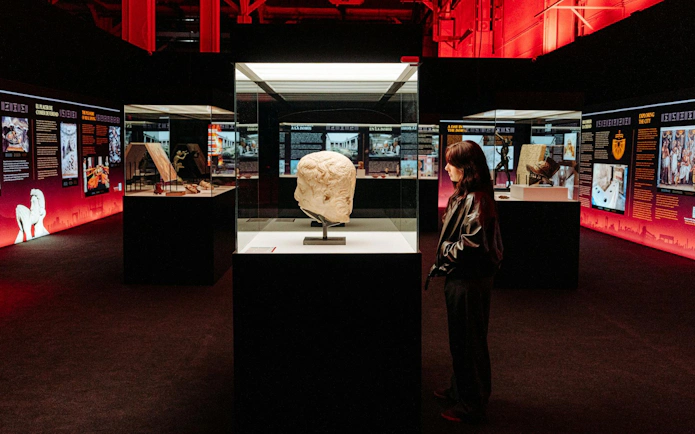 Pompeia exhibit at IDEAL Barcelona with visitor viewing ancient sculpture.
