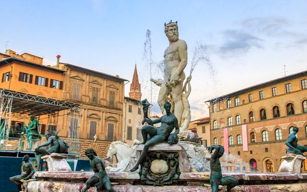 Fountain of Neptune in Florence's Piazza della Signoria with surrounding statues.