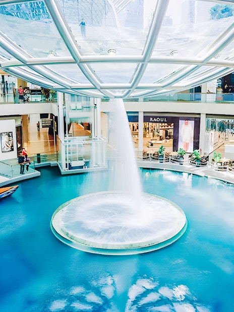 Indoor canal and waterfall feature inside Marina Bay Sands shopping mall.