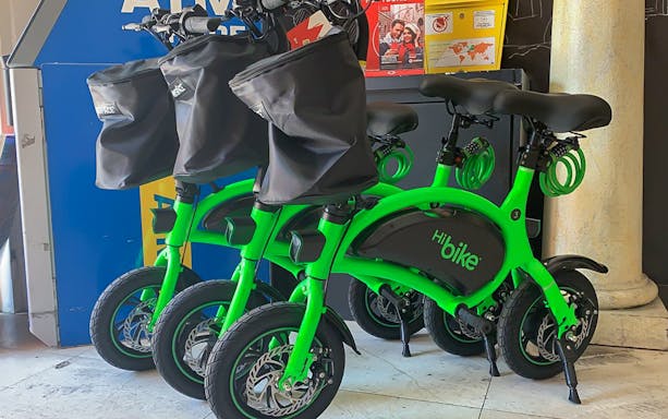 Green e-bikes available for rental near Circus Maximus, Rome.