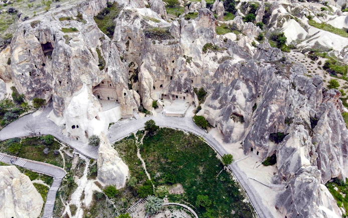 Cappadocia rock formations and ancient cave dwellings on a guided tour path.