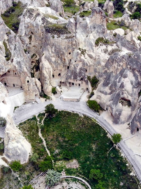 Cappadocia rock formations and ancient cave dwellings on a guided tour path.