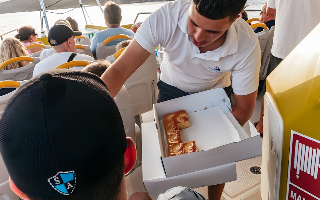 Tourist receiving snacks on a speedboat during Sunset Dolphin Cruise.