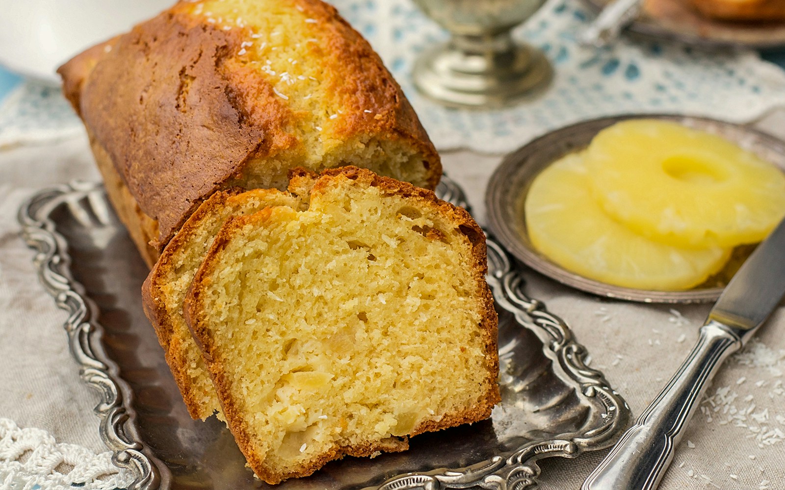 Moist pineapple snack cake with a golden crust on a white plate.