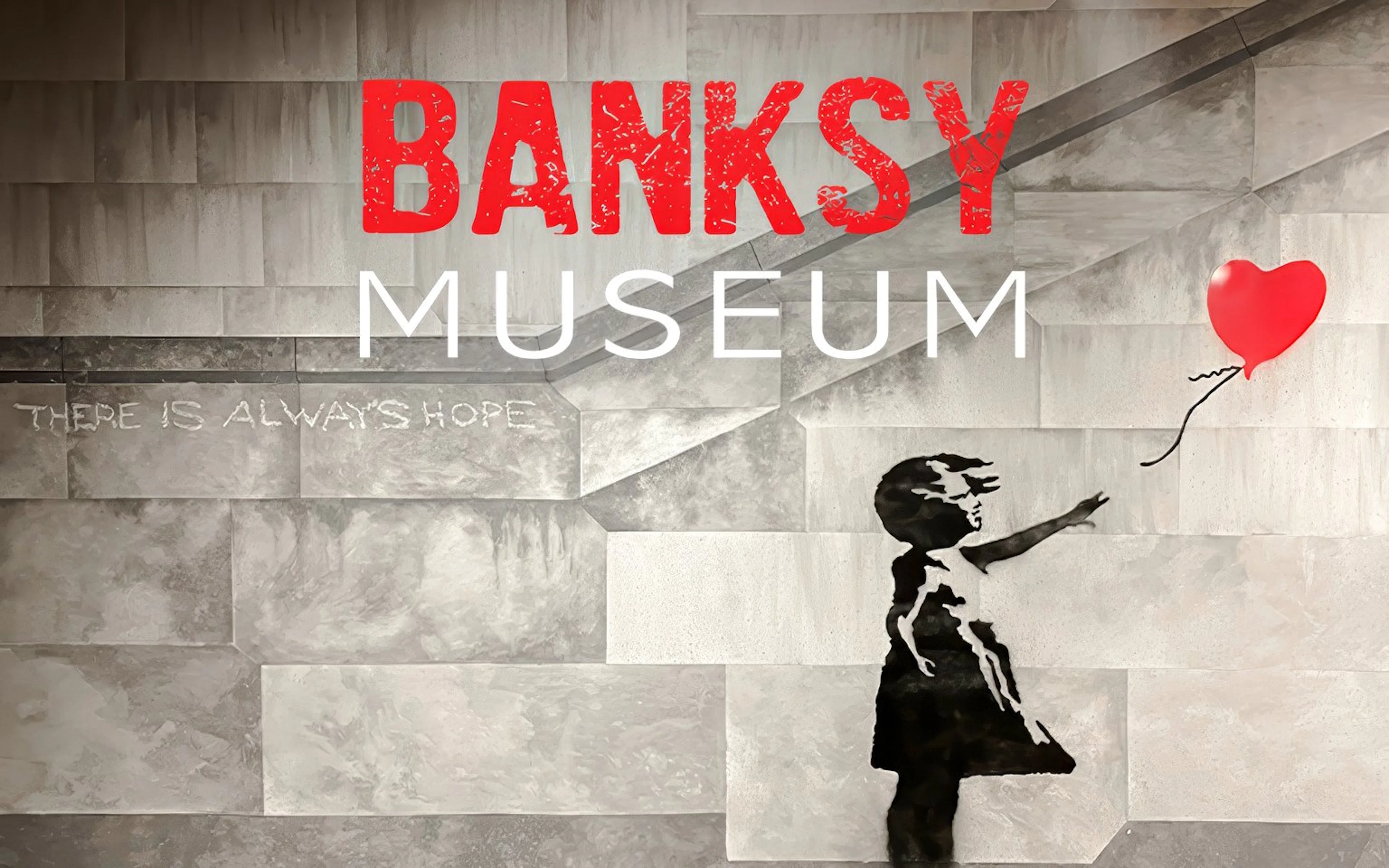 Banksy Museum mural with girl reaching for red balloon, text "There is always hope.
