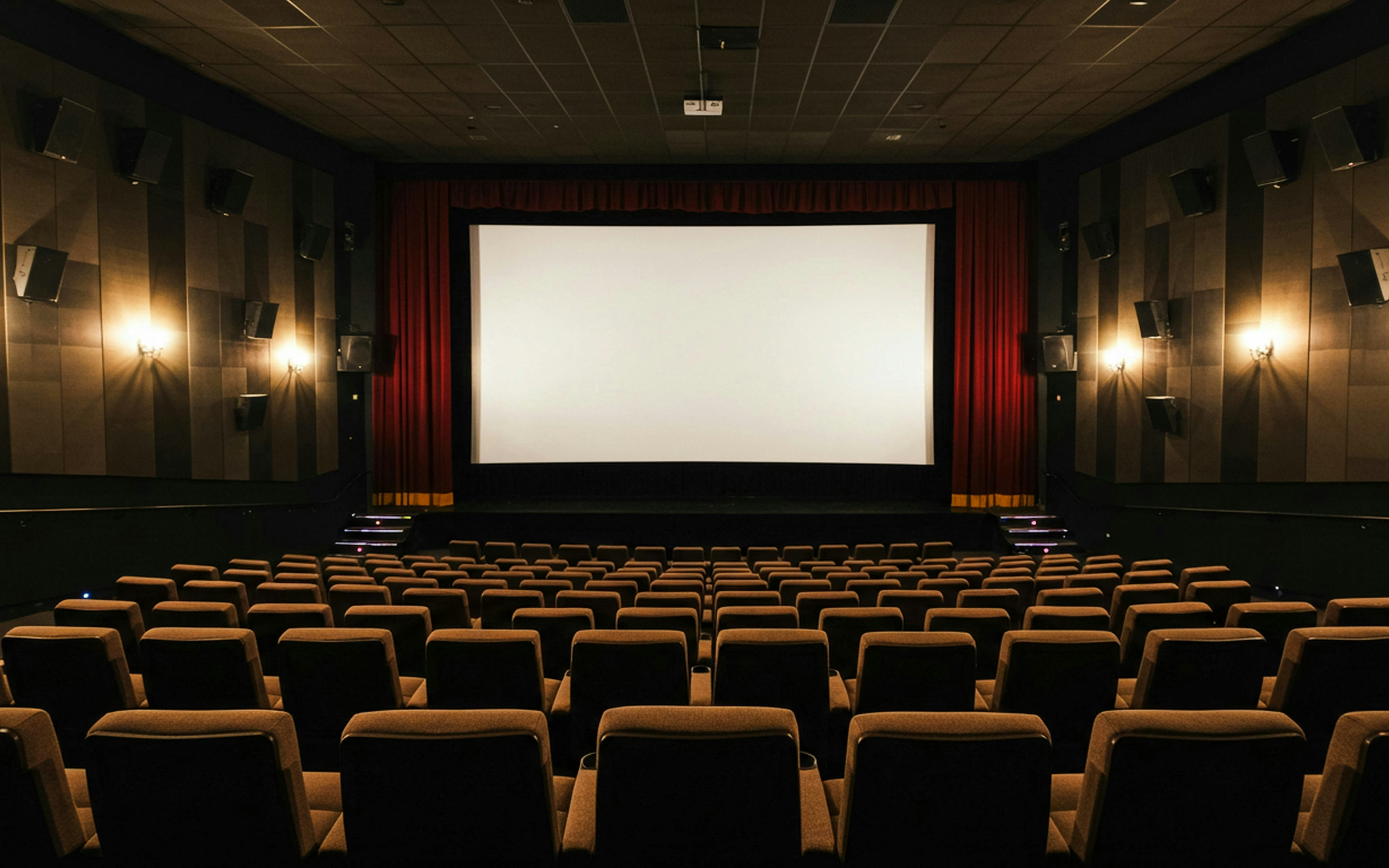 Interior of a theater at Caumont Centre d’Art with empty seats facing a large screen.