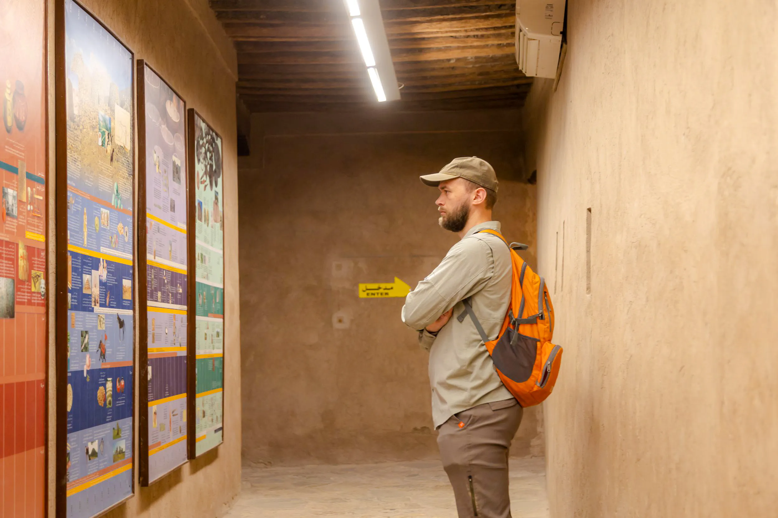 Visitor examining historical displays at Nizwa Fort during Muscat day trip.