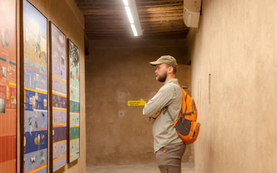 Visitor examining historical displays at Nizwa Fort during Muscat day trip.
