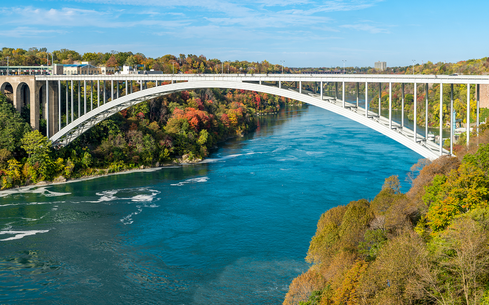 Rainbow Bridge connecting USA and Canada with Niagara Falls in the background.