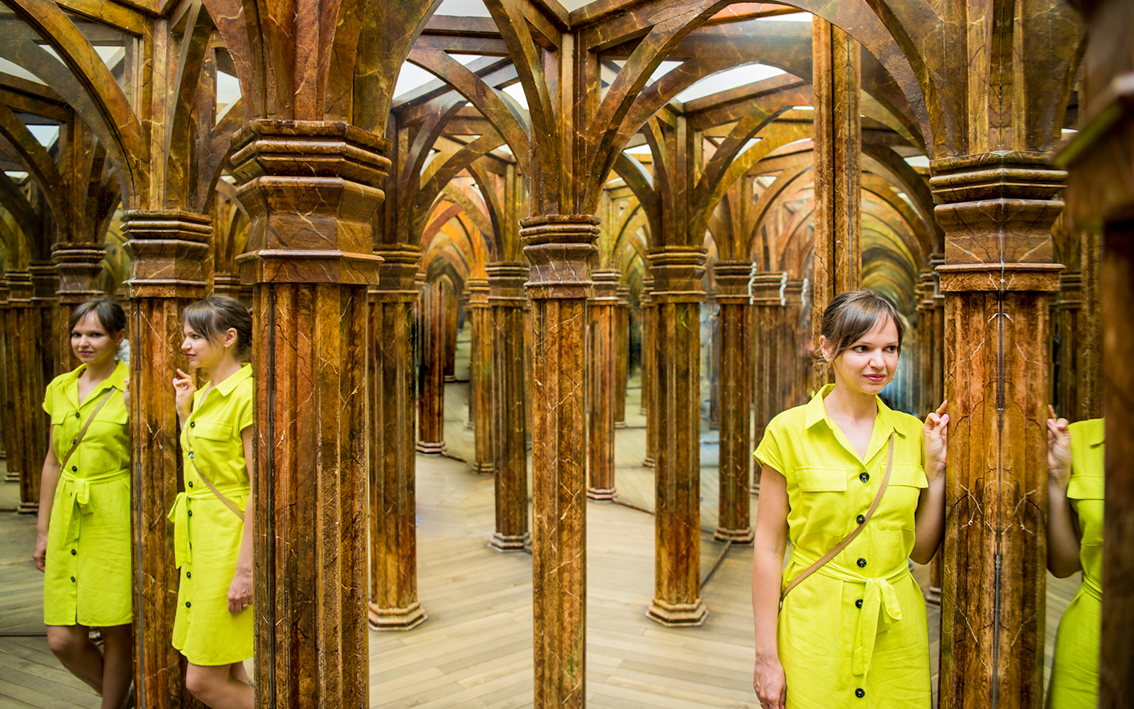 Guest navigating intricate Mirror Maze with reflections.