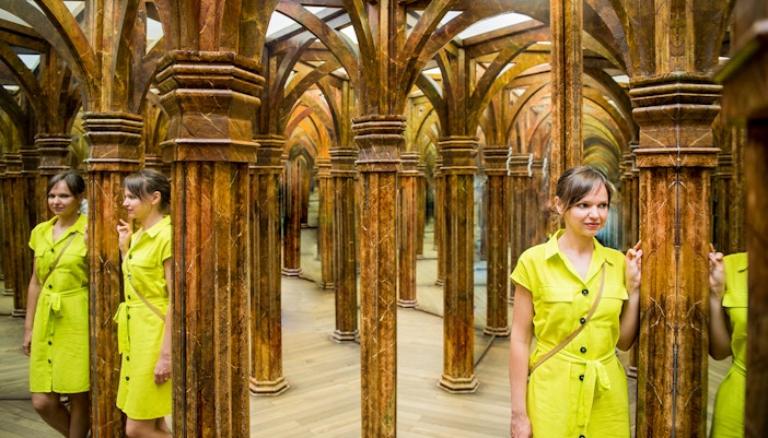 Guest navigating intricate Mirror Maze with reflections.