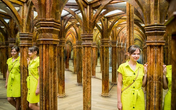 Guest navigating intricate Mirror Maze with reflections.