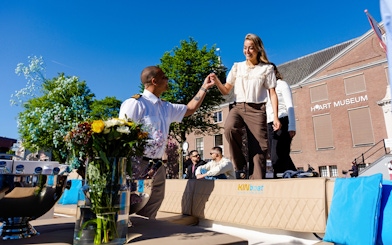Guests boarding an open boat cruise in Amsterdam with a guide assisting near H'ART Museum.