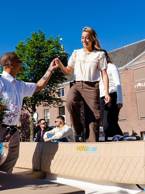 Guests boarding an open boat cruise in Amsterdam with a guide assisting near H'ART Museum.