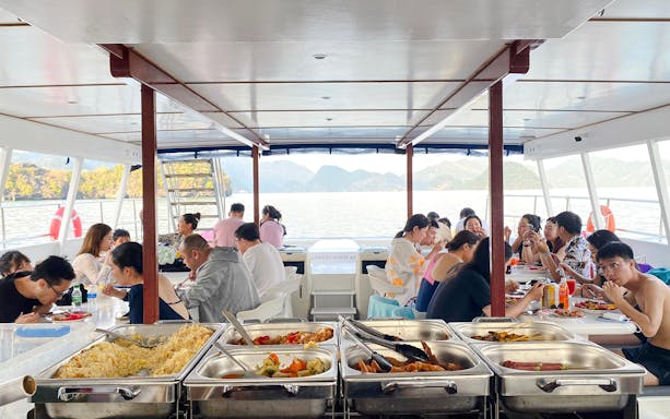 People dining on a Langkawi sunset cruise with buffet and scenic ocean view.