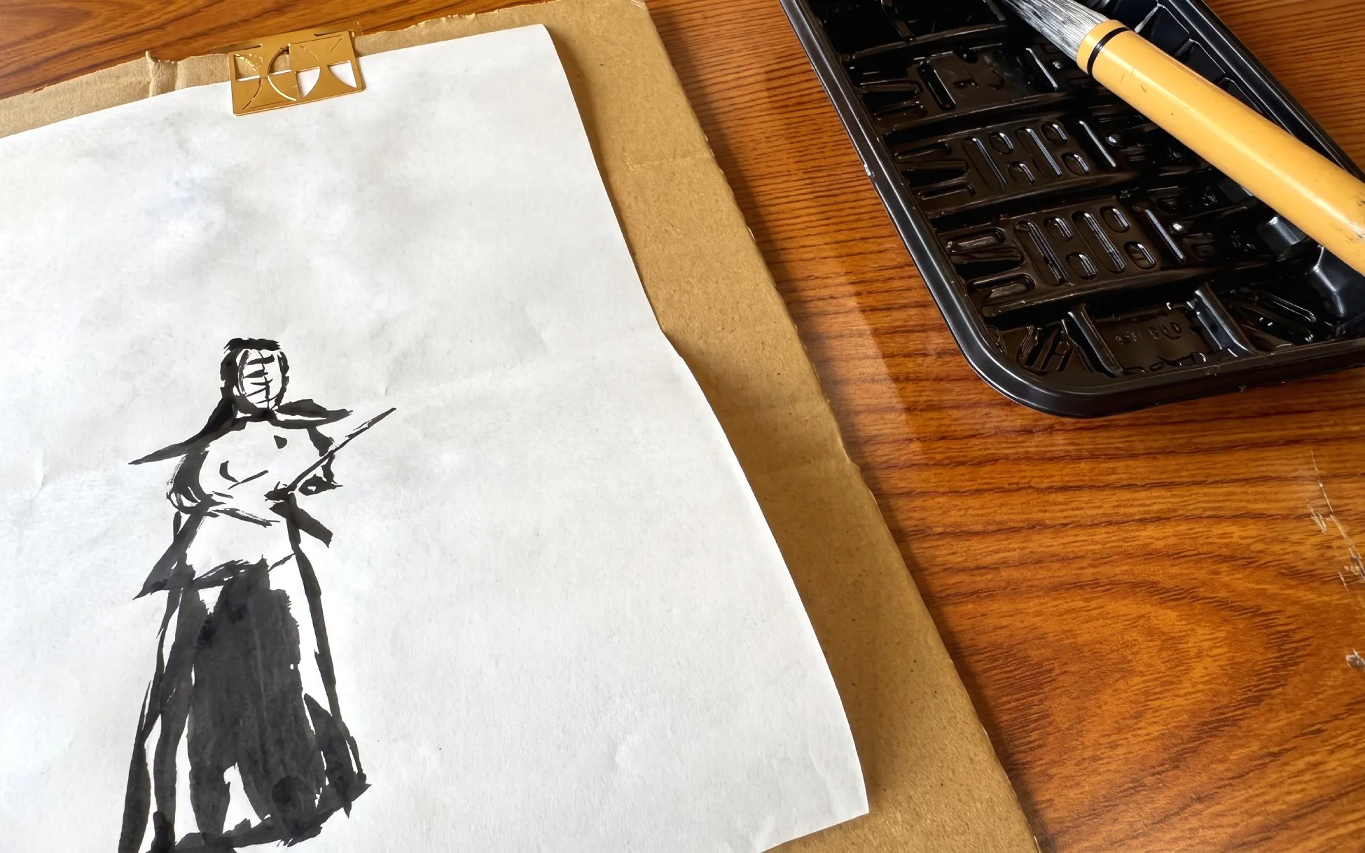 Samurai ink drawing with brush and tray on wooden table, Sapporo experience.