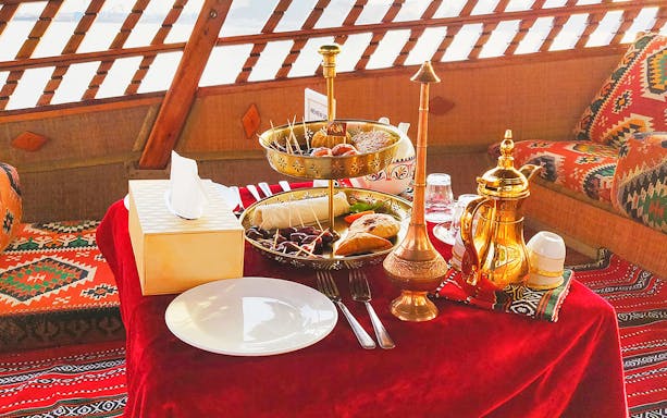 Emirati high tea setup on an abra with traditional snacks and tea set during Burj Khalifa sunset tour.