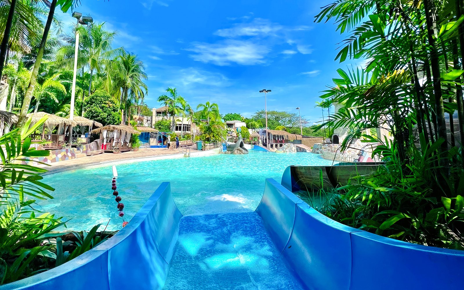 Water slide leading into a pool at Wet World Water Park Shah Alam on a sunny day.