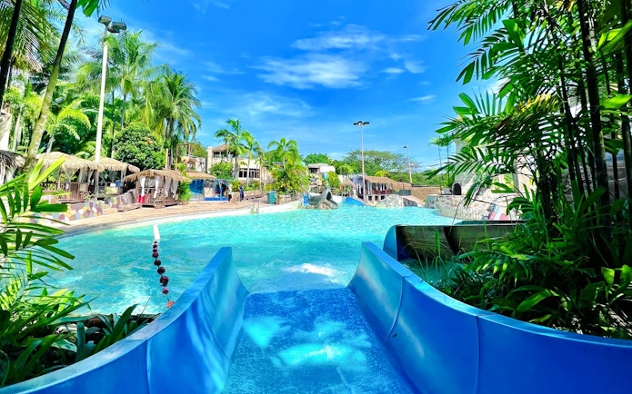 Water slide leading into a pool at Wet World Water Park Shah Alam on a sunny day.
