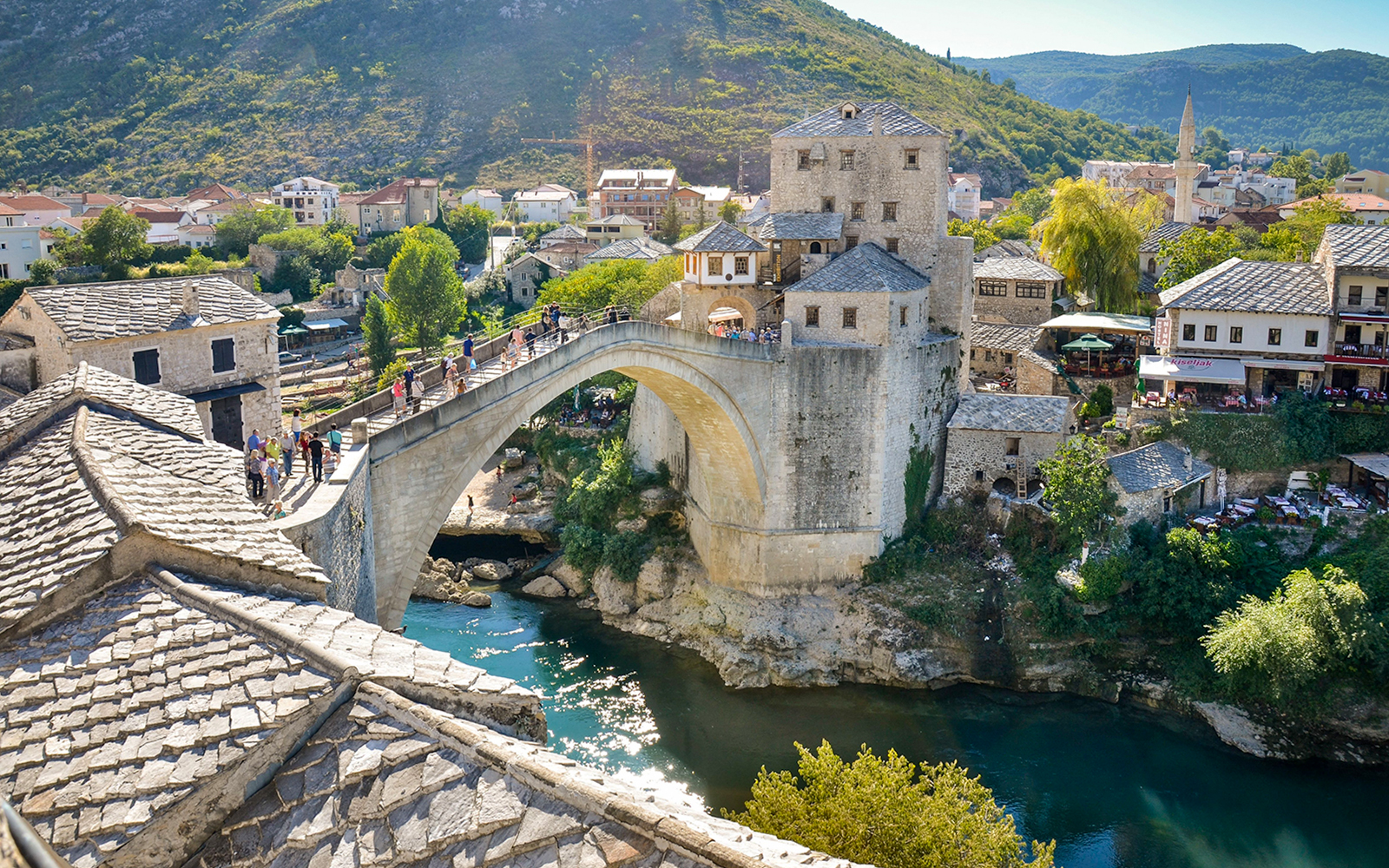 Mostar Bridge spanning the Neretva River with surrounding historic buildings in Mostar, Bosnia and Herzegovina.