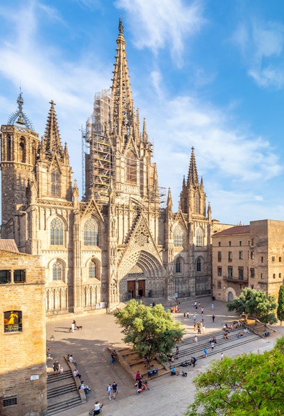 Cathedral of Barcelona with visitors in the plaza, showcasing Gothic architecture.