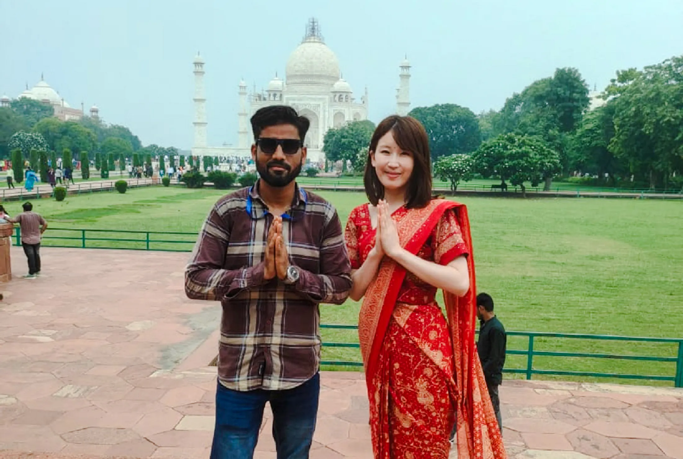 Visitors posing in front of the Taj Mahal during a tour from Delhi to Agra.