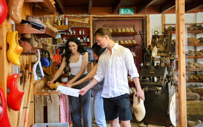 Guests participating in a clog-making workshop, displaying traditional wooden shoes.