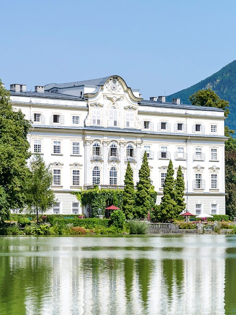 Leopoldskron Palace with lake and mountain backdrop, Salzburg, Austria.